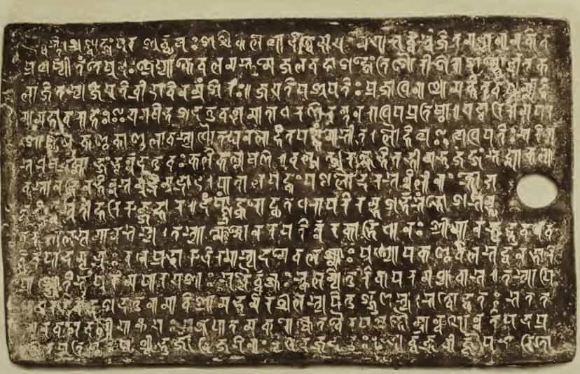A dark copperplate photographed in 1897, fourteen lines of raised script and a ring hole at its right edge