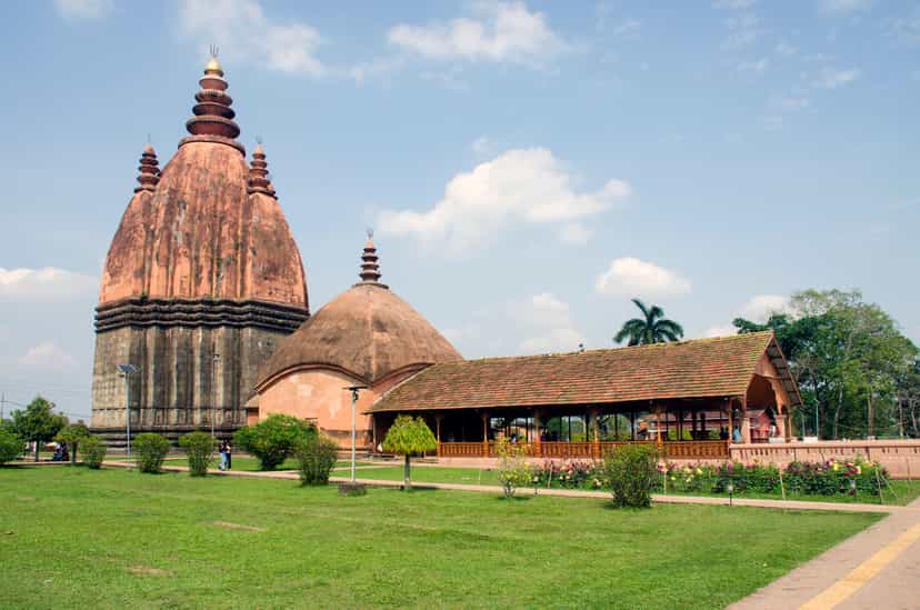 The tall curvilinear brick spire of the Sivadol rising above its mandapa hall at Sivasagar