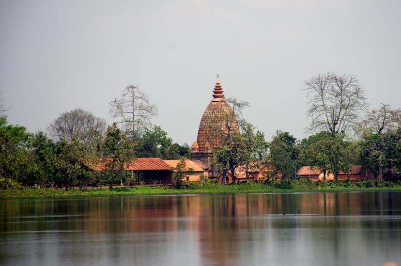 The Joysagar tank seen across the water to a bankside Ahom dol temple and a low pillared hall, reflected in the great sheet of water