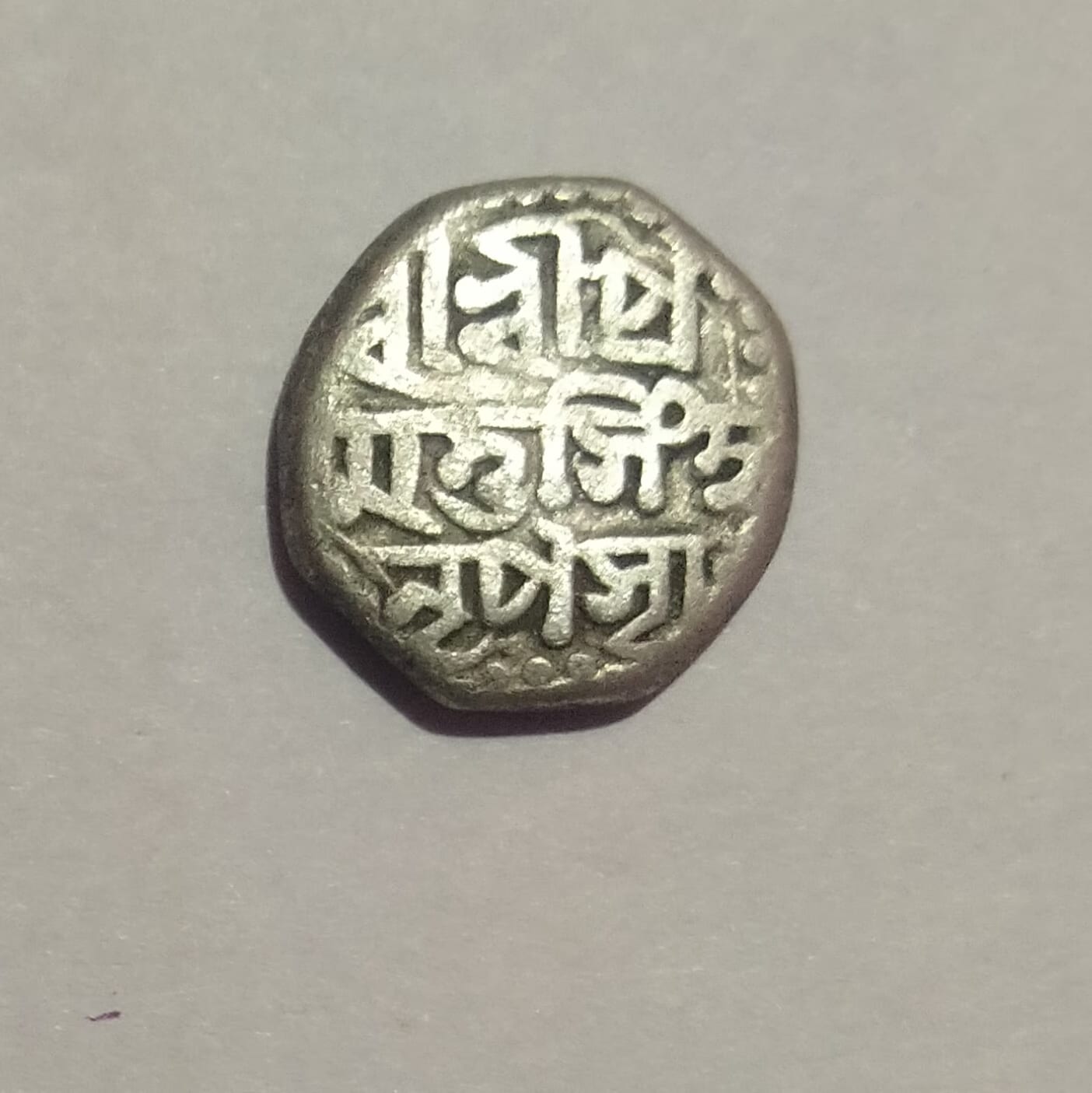 An octagonal Ahom silver rupee with multi-line legend in Assamese script recording the king's name and titles