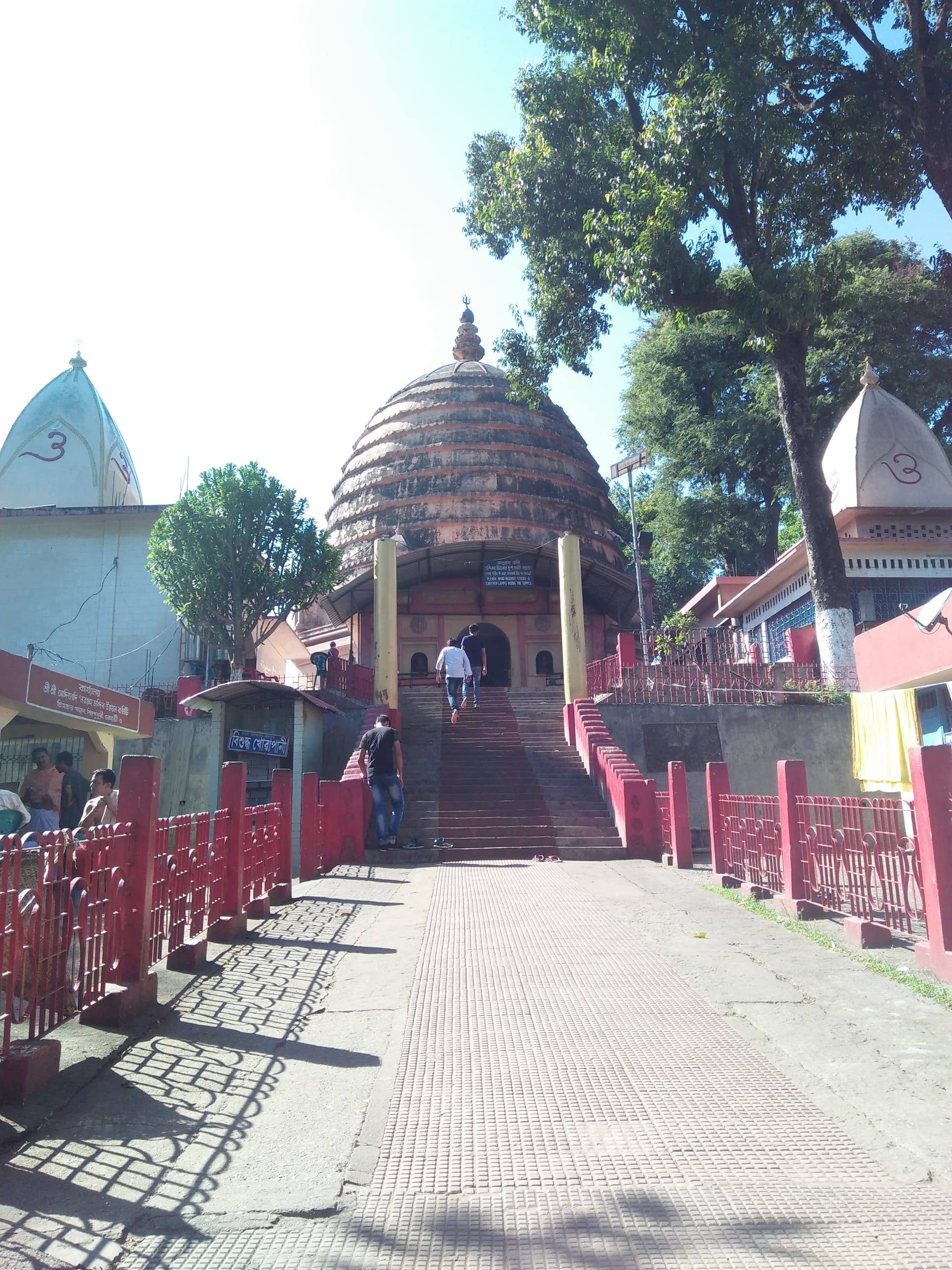 The ribbed beehive-shaped dome of the Navagraha temple atop its hill, with steps leading up between flanking shrines