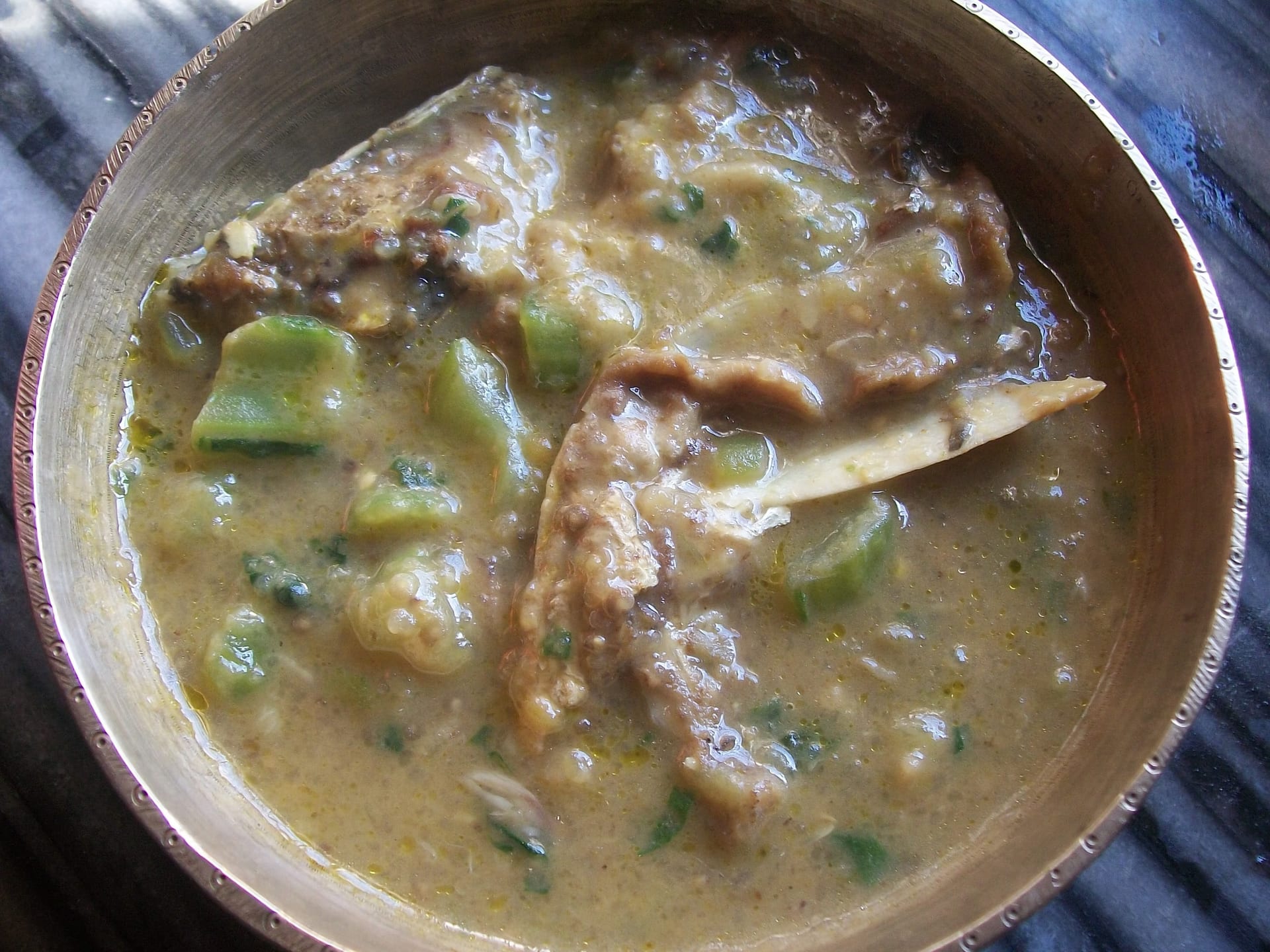 A bowl of fish-head khar, an alkaline curry with raw papaya, seen from above