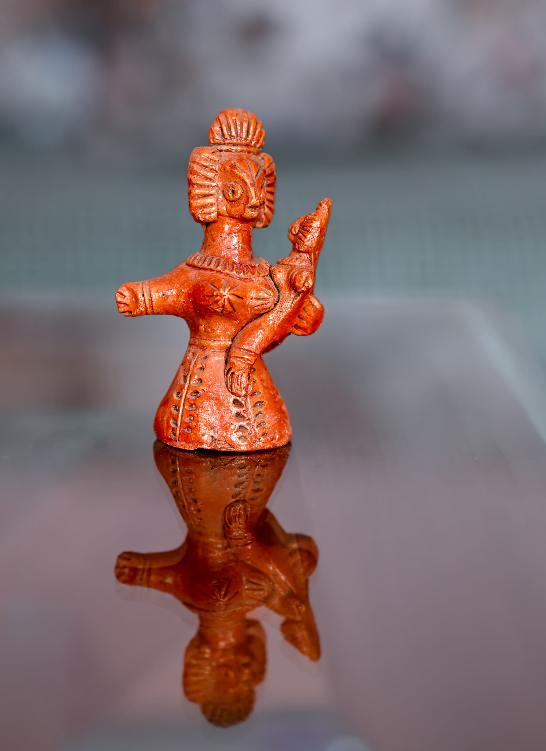 A single hatima putul: a terracotta mother figure with a flared headdress holding a child
