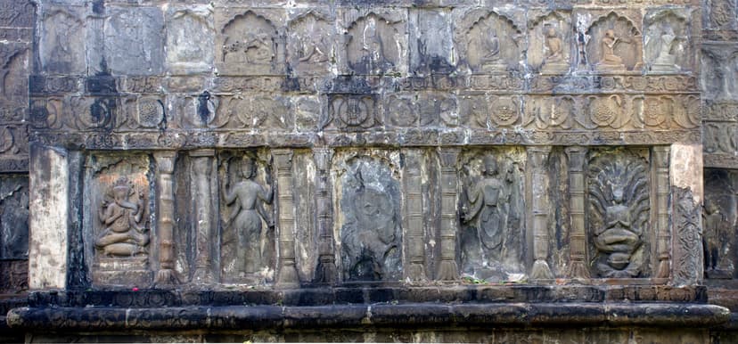 Relief panels on the Joydol outer wall at Joysagar: deities in niches including Ganesha, a floral mid-band, and smaller arched figures above