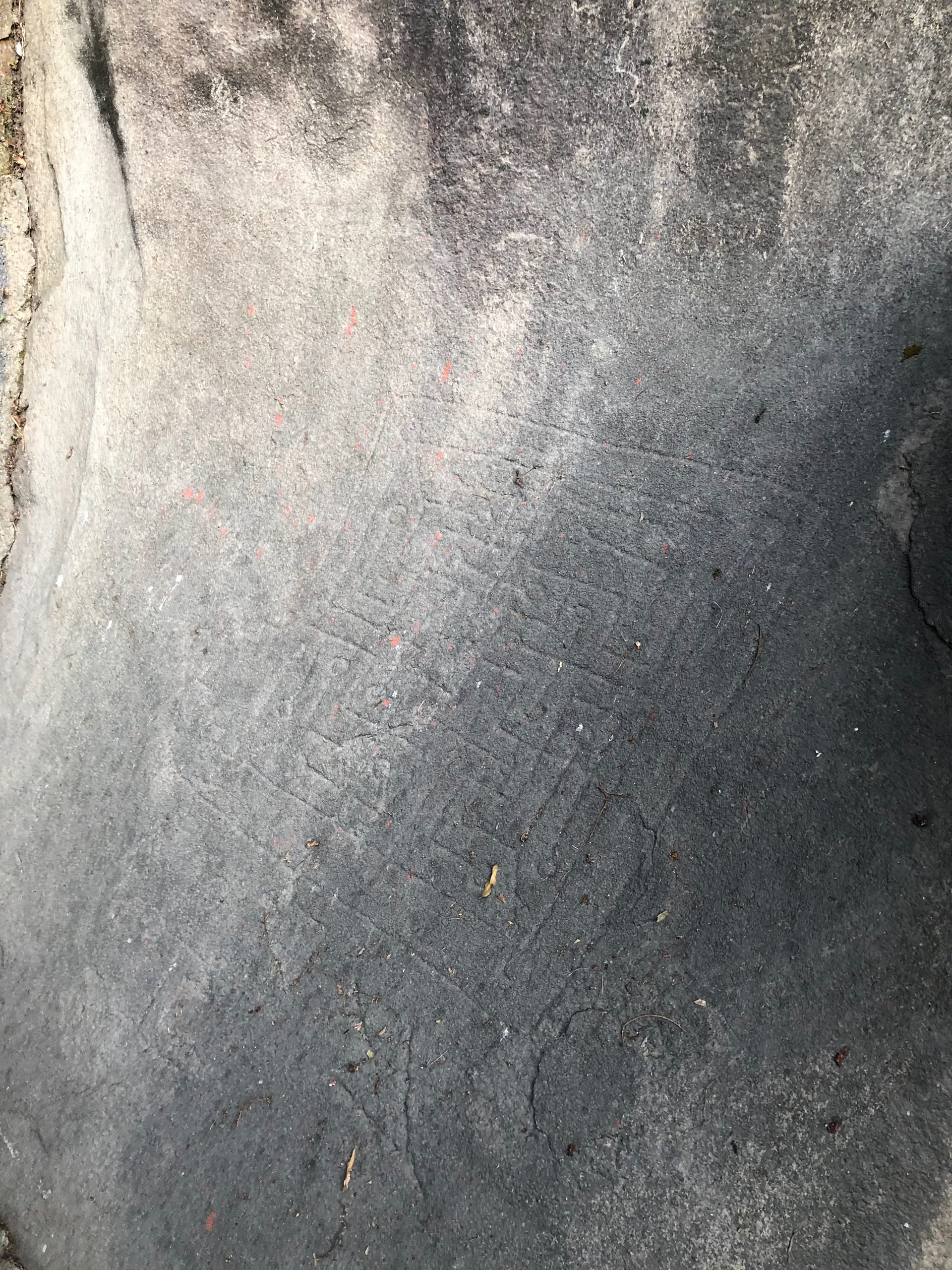 A rectangular gaming board cut into weathered granite at Kanai Boroxi Bowa, North Guwahati