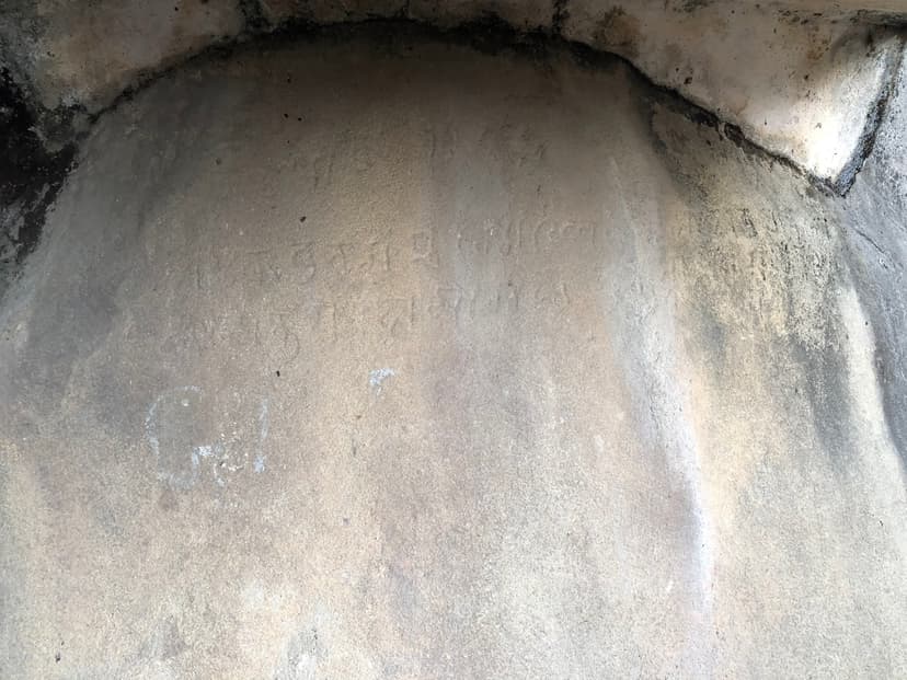 Faint rows of incised characters on a pale domed rock surface, the laconic 1206 inscription at Kanai Boroxi Bowa