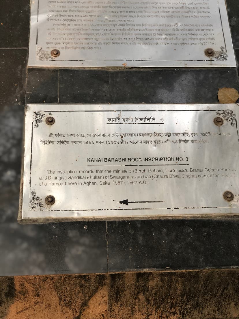 A bilingual metal site plaque reading Kanai Barashi Rock Inscription No. 3, recording an Ahom rampart of Saka 1589 / 1667 CE