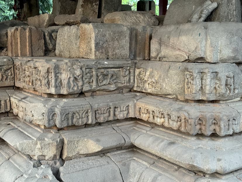 A stepped moulded stone temple base with horizontal courses of small carved figures and floral mouldings