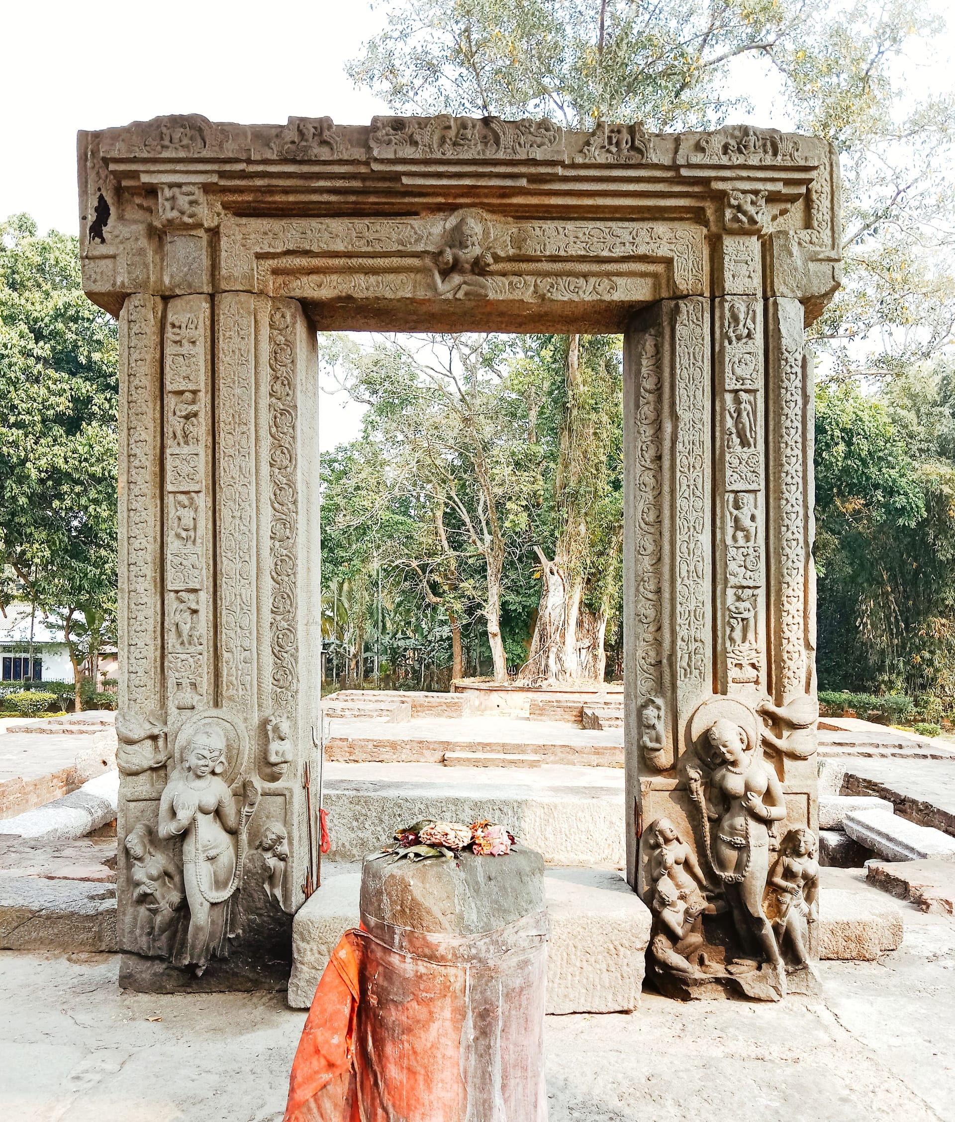 Carved stone temple doorframe with flanking river-goddess figures and ornamented jambs and lintel